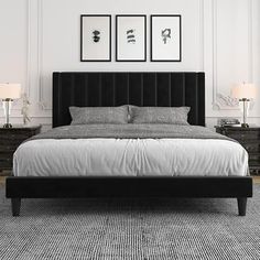 a black and white bedroom with two pictures on the wall above the bed, along with an upholstered headboard