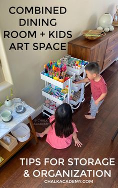 two children playing with toys in the corner of a room that is filled with art and storage