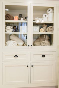 a white cabinet filled with lots of towels