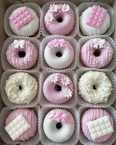 a box filled with pink and white donuts covered in frosting