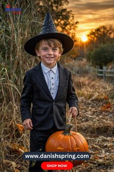 a young boy dressed in a suit and hat holding a jack - o'- lantern