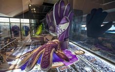 gloves and other items are on display in a glass case