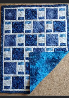 two blue and white quilts on the floor