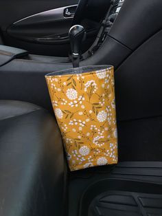 the interior of a car with a yellow and white flowered bag in the passenger seat