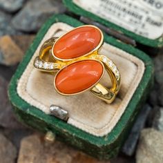 This gorgeous coral ring is centered with two (2), bezel set, oval cabochon cut natural coral. The ring features a split shank design and is accented with eight (8), bead set, round brilliant cut diamonds. The ring measures 18.1mm at the top, rises 5.7mm above the finger, tapering to 2.9mm wide and 1.3mm thick at the base of the shank. "K18 D0.11" is stamped on the inside shank. The ring is currently a size 6.5. Luxury Red Coral Jewelry For Formal Occasions, Orange Oval Cabochon Jewelry For Formal Occasions, Elegant Coral Rings For Anniversary, Coral Oval Jewelry For Weddings, Formal Orange Oval Cabochon Ring, Elegant Coral Oval Rings, Formal Coral Oval Jewelry, Formal Coral Jewelry With Cabochon, Elegant Oval Coral Rings