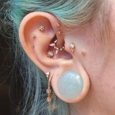 a close up of a person's ear with different piercings on the side