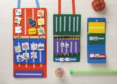 several different colored binders and magnets on a white table with crayons