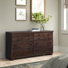 a bedroom with a dresser and pictures on the wall