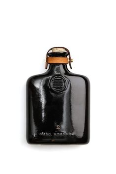 an old fashioned black flask bottle on a white background