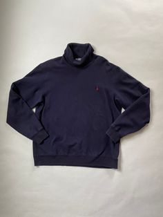 "Polo Ralph Lauren Mock Neck Sweatshirt Size: Tag Size Large - Fits Medium Era: Late 90's - Early 2000's Material: 85% Cotton, 15% Acrylic Made in Hong Kong Details: Navy Long Sleeve Sweatshirt with Mock Neck/Turtle Neck and Red Polo Logo.  Good Condition with Some Slight Fade.  No Major Defects, Holes, or Stains.  Chest (Armpit-Armpit) : 23\" Sleeve (Shoulder-SleeveEnd) : 26 - 26.5\" Length (Neckline-Bottom) : 27.5\"" Classic Navy Tops With Ribbed Cuffs, Navy Winter Top With Ribbed Collar, Classic Cotton Funnel Neck Tops, Classic Navy Tops For Winter, Classic Navy Top For Winter, Casual Polo Sweater With Funnel Neck And Ribbed Cuffs, Navy Turtleneck Winter Top, Navy Turtleneck Tops For Winter, Casual Cotton Top With Funnel Neck