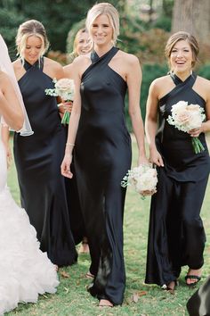 a group of women standing next to each other on top of a grass covered field