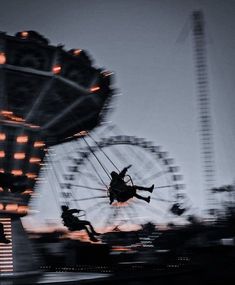 an image of people riding on a ferris wheel at dusk or dawn in the city