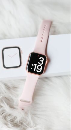 an apple watch sitting on top of a white box next to a pink and black watch