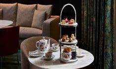 a table topped with cups and saucers filled with desserts on top of it