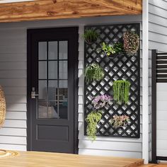 an outdoor patio area with a wicker chair and potted plants on the wall