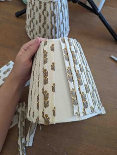 someone is holding up some fabric to make lampshades