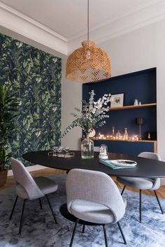 an elegant dining room with blue walls and floral wallpaper