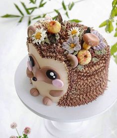 a hedgehog cake is decorated with flowers and leaves