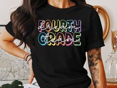 Celebrate the new school year with this colorful "Fourth Grade" T-Shirt. Perfect for teachers and students, this vibrant design adds fun to any school wardrobe. Ideal for back to school, classroom events, and daily wear.  WELCOME TO RAIN APPAREL US  We are a small business located in Missouri. We started making t-shirts in 2019 and have grown so much since then! We take pride in the quality of our products and are always striving to grow. We hope you can find whatever you are looking for in our shop. Please reach out to our team if you need any help at all! Quality Assurance: We pride ourselves on using high-quality fabrics and safe inks. Our suppliers assure our high standards for working conditions for your peace of mind, and ours as well.  PRODUCT INFORMATION  * We use Bella Canvas bran Multicolor Letter Print T-shirt For School Events, Multicolor Letter Print Shirt For Back To School, Multicolor School Spirit T-shirt With Text Print, Multicolor Text Print T-shirt For School Spirit, Multicolor Letter Print T-shirt For College, Multicolor School T-shirt With Text Print, School Multicolor Text Print T-shirt, Multicolor Text Print T-shirt For School, Multicolor Short Sleeve T-shirt For College