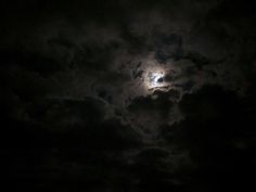 the moon is shining brightly in the dark clouds