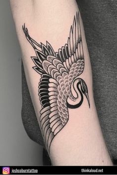 a black and white bird tattoo on the arm