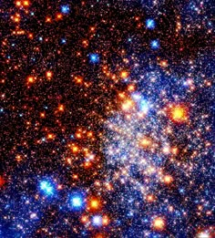 a cluster of stars in the sky with blue and red lights on it's sides