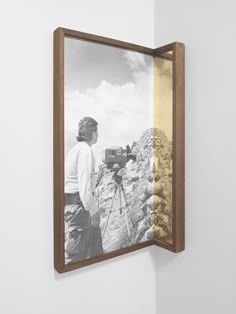 a black and white photo is hanging on the wall next to a wooden framed photograph