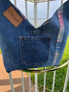 a bag made out of jeans hanging on a rack with a tag attached to it