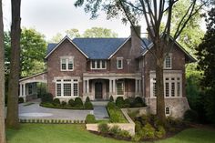 a large brick house surrounded by trees and bushes