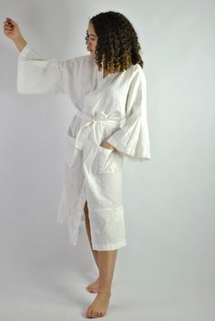 "This is our no. 60 of Conscious Clothing Concept #stayhome This lovely white A-line loose fitting robe is made of pure quality linen. Very modern approach to traditional white spa gown. It has got very flattering wide sleeves that match the bottom of the dress. This unique piece of loungewear can be very versatile. It is great and comfy to wear around the house, hotel or spa. It can be treated as the dress or loose shirt over the shorts for summer look. Perfect for home and the beach. It is the White Kimono Sleeve Dresses For Loungewear, White Relaxed Fit Daywear Robe, White Relaxed Fit Kimono For Loungewear, Oversized Robe With Kimono Sleeves For Daywear, Oversized Kimono Sleeve Robe For Daywear, White Kimono For Brunch In Summer, White Relaxed Fit Kimono With Kimono Sleeves, White Relaxed Fit Kimono For Spring, White Long Sleeve Relaxed Fit Kimono