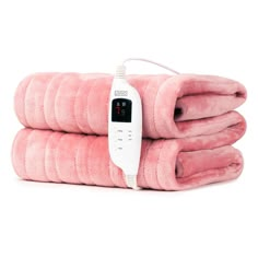 three pink towels stacked on top of each other with an electric thermometer attached to them