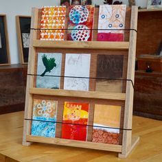 a wooden shelf filled with lots of different colored cards on top of a wooden table