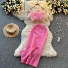 a white teddy bear laying on top of a floor next to a hat and pink leggings