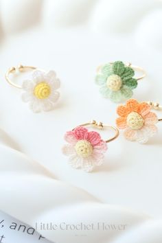 three crochet flower rings sitting on top of a white sheet