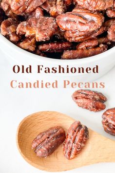 a bowl full of candied pecans sitting on top of a table next to a wooden spoon