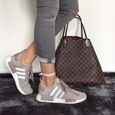 a woman standing next to a handbag and purse on top of a carpeted floor