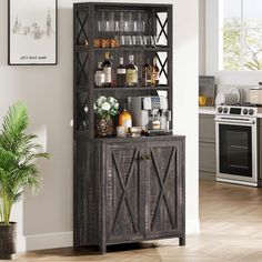 a wooden cabinet with wine glasses and bottles on it in a kitchen next to a potted plant