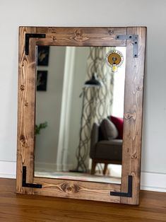 a mirror sitting on top of a wooden floor in front of a wall mounted light