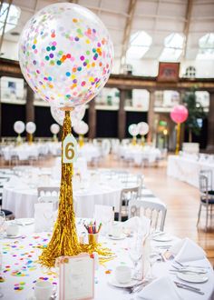 the table is set up with balloons and confetti