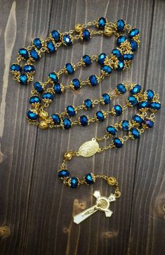 St Benedict Deep Blue Rosary Necklace 10.00mm beads made of crystallized glass, a long beaded catholic necklace classic communion rosary in total length of 20".Honored 1.6" Cross of St Benedict made of plated gold alloy zinc, exceptionally durable preventing corrosion and tarnish.Five decades Rosary necklace connected in a total of 59 devout beads with golden crown Mysteries beads, it's perfectly designed to hold on during intensive daily usage praying and carrying it with you.Cross (H X W) : 4 Simple Leg Tattoos, Blue Rosary, Catholic Necklace, Pearl Rosary, Golden Crown, St Benedict, Saint Benedict, Rosary Necklace, Gold Alloys