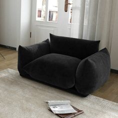 a black couch sitting on top of a white rug