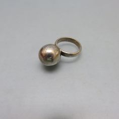 This interesting ring is sterling silver in a very Danish Modern design. It is an uncomplicated round silver but not sterling ball or sphere measuring 5/8ths inches high soldered to a plain sterling silver band. The ring is a size 6 1/4 which makes it a perfect ring finger or pinkie ring. It is in very good vintage condition with one tiny ding on the bead ball. The band is marked, 925 for sterling and tests as such. The band measures 3/16ths inches high.  This will arrive in a lovely ring box fo Vintage Silver Domed Jewelry, Silver Domed Minimalist Rings, Silver Domed Minimalist Jewelry, Minimalist Silver Domed Rings, Pinkie Ring, Bead Ball, Gift Presentation, Bolo Ties, Safe Storage