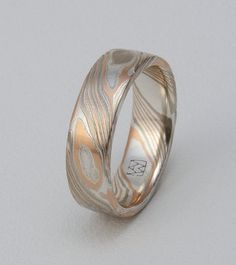 a wedding ring with an intricate design on it's side, against a white background