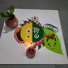 a decorated cake with candles on top of it next to a potted plant and other decorations