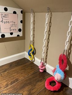 two stuffed animals hanging from chains in a playroom with a sign that says sweet dreams little love