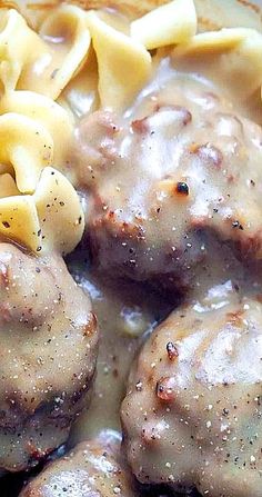 meatballs covered in gravy and pasta on a plate