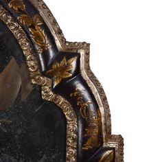 an ornately decorated mirror with gold trimmings and black marble surround the frame