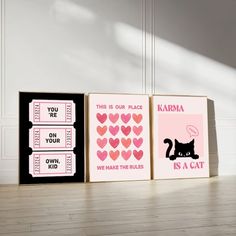 three canvases with pink and black designs on them, one has a cat in the middle