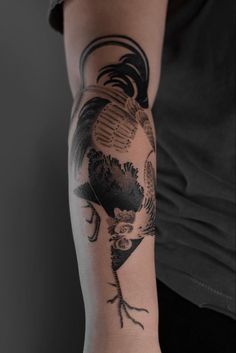 a man's arm with a rooster tattoo on it