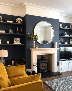 a living room filled with furniture and a fire place in front of a mirror on the wall